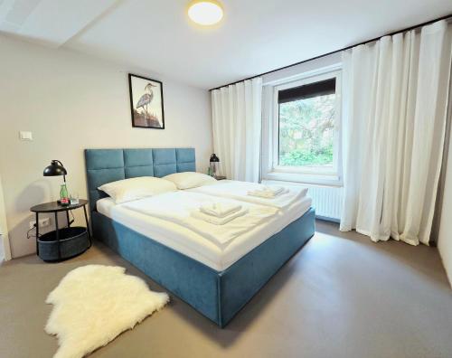 ein Schlafzimmer mit einem blauen Bett und einem Fenster in der Unterkunft Hotel Restaurant Joseph in Bruckneudorf
