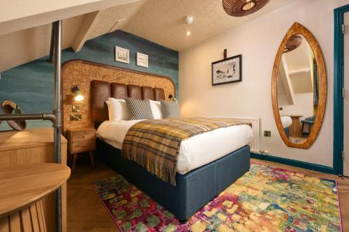 a bedroom with a large bed and a mirror at Great Western in Newquay