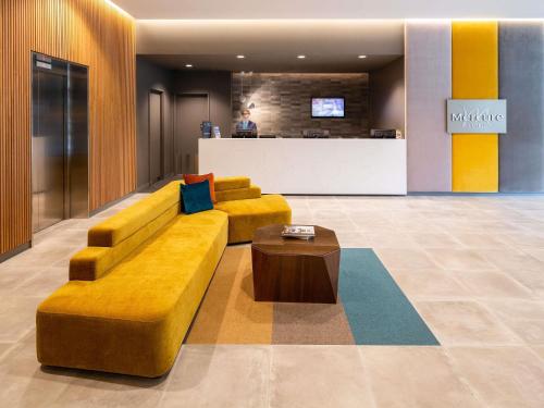 a lobby with a couch and a coffee table at Mercure Canberra Belconnen in Canberra