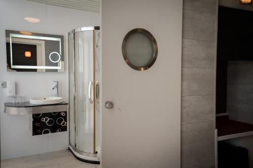 a bathroom with a shower with a mirror and a sink at Hotel Richmond in Blankenberge