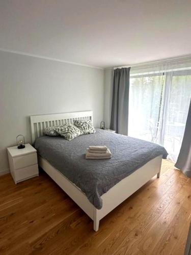 sypialnia z łóżkiem i dużym oknem w obiekcie Albatross Mini - 2 Room Seaside Air-conditioned Apartment with Balcony w mieście Ķesterciems