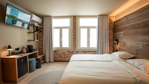 a hotel room with a bed and a television at Hotel Richmond in Blankenberge