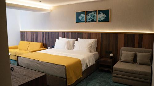 a hotel room with a bed and a chair at Hotel Central in Inđija