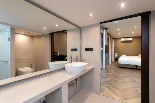a bathroom with two sinks and a large mirror at OHASIS by OH Hotels in Bangkok