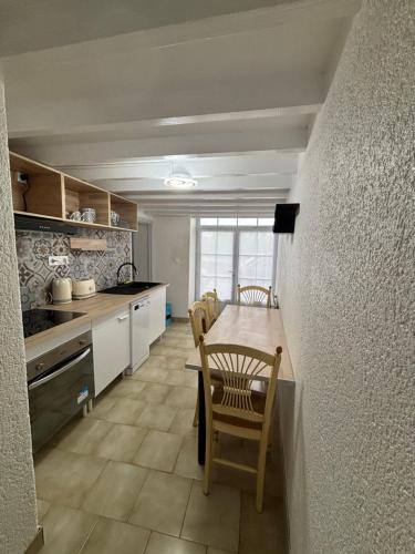 a kitchen with a table and chairs in a room at Toue de Loire in Chaumont-sur-Loire