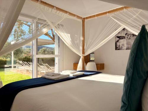 a bedroom with a canopy bed with a window at Lucky Crane Villas in McGregor