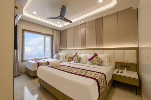 a hotel room with two beds and a window at Holiday Homez, City Centre with Free Airport & Train Station Pickup in New Delhi