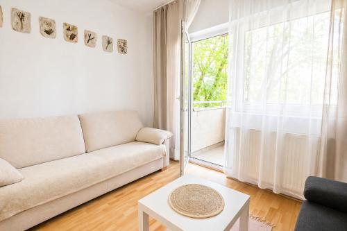 a living room with a couch and a window at Héthajnal Apartman in Debrecen
