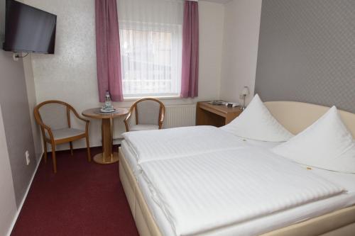 a hotel room with a bed and a small table at Pension Der kleine Nachbar in Gotha