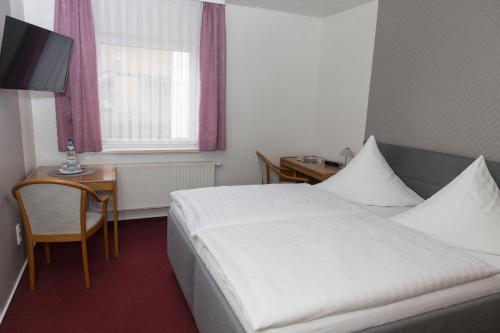 a hotel room with a bed and a table and a window at Pension Der kleine Nachbar in Gotha