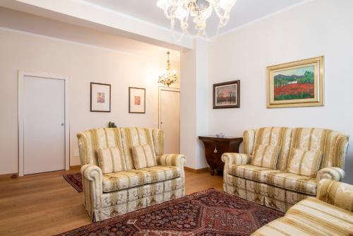 a living room with two chairs and a chandelier at Residenza Maria Luisa in Padova