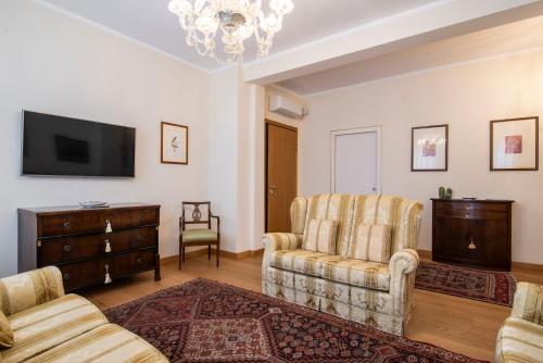 a living room with two chairs and a flat screen tv at Residenza Maria Luisa in Padova