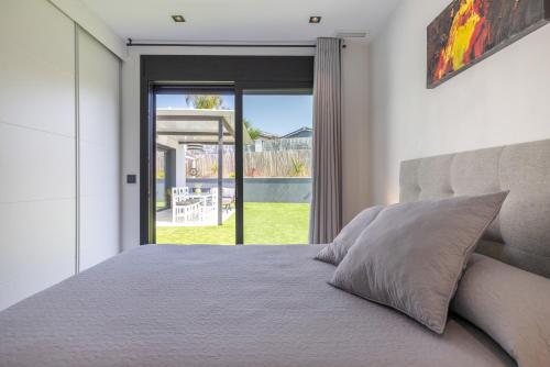 a bedroom with a bed and a sliding glass door at La Villa del Roc in Roda de Bará