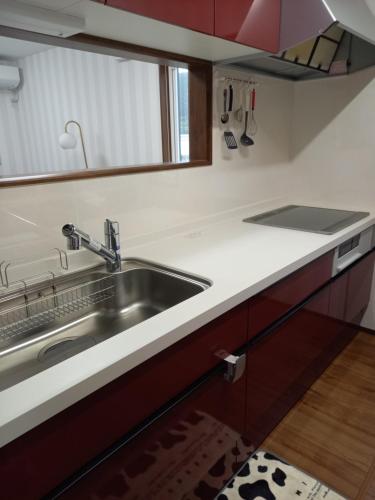 a kitchen with a sink and a counter top at ミエル富士 in Oishi