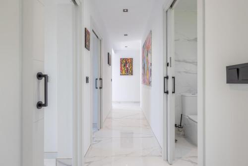 a hallway with white walls and a mirror at La Villa del Roc in Roda de Bará