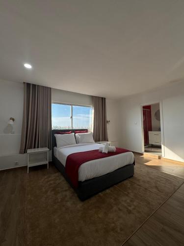 a bedroom with a large bed and a large window at Onzo Yamy in Luanda