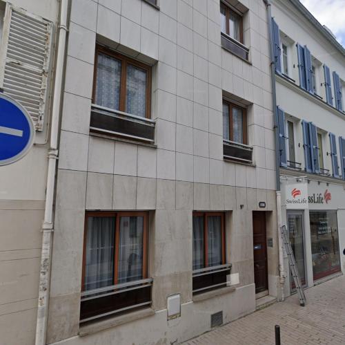 a building with windows on the side of it at En Centre ville Gare et commerces in Vincennes