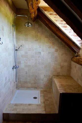 a bathroom with a shower in a attic with a sink at Mas De Garrigue - Chambres d'hôtes in Calvignac