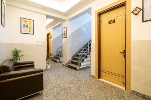 a hallway with a yellow door and stairs at Treebo Premium Inn 62 in Noida