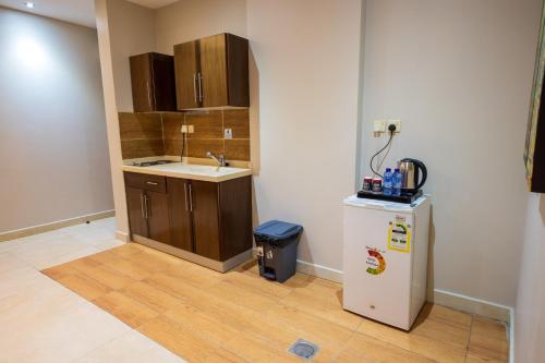 a kitchen with a sink and a refrigerator at Golden New Hira Serviced Apartments in Jeddah