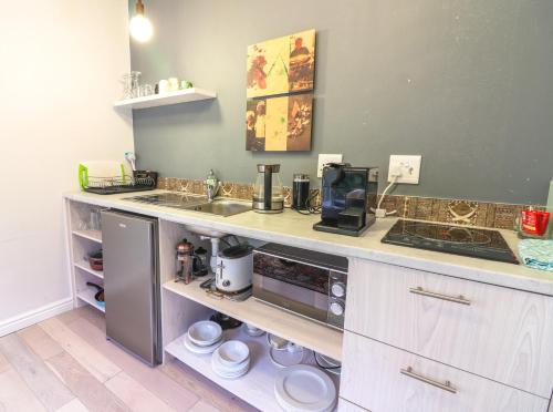 a kitchen with a counter with a sink and a stove at Airconditioned Apartment for 3 guests. in Hermanus