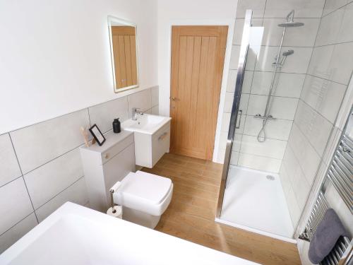 a white bathroom with a toilet and a shower at Stewards House in Tadcaster