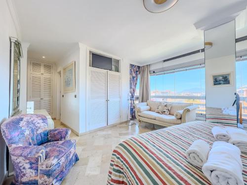 a bedroom with a bed and a chair and a couch at Parque Marbella Three Bedroom Apartment in Marbella