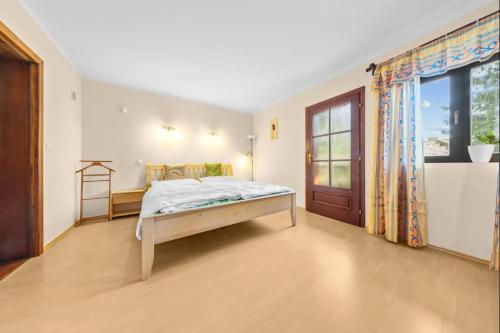 a bedroom with a bed and a large window at Chata Danube in Gabčíkovo