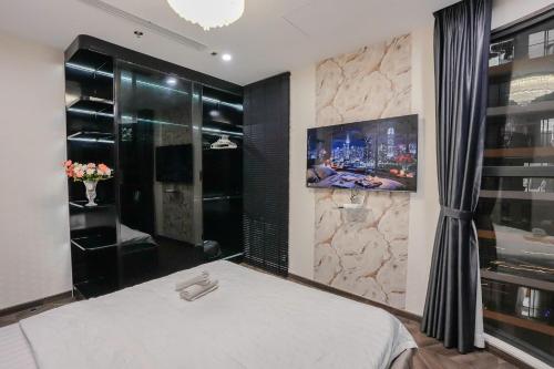 a bedroom with a bed and a tv on a wall at Shi House -Modern Luxury 2BR Apartment BE3 Beverly in Ấp Thạnh Lộc