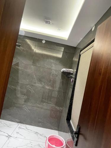 a bathroom with a shower with a glass door at Purav Hotel in Kharkhauda