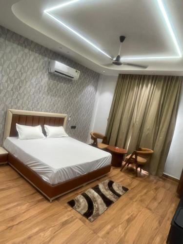 a bedroom with a white bed and a ceiling at Purav Hotel in Kharkhauda