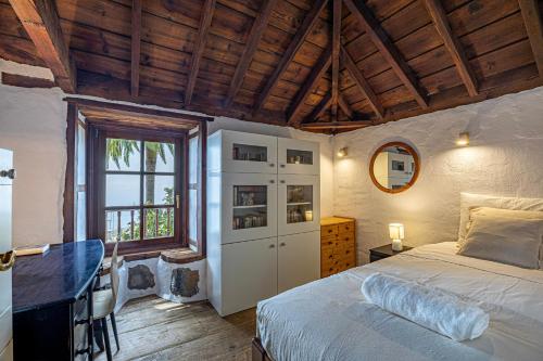 a bedroom with a bed and a desk and a window at Casa Piedra y Tea in Tijarafe