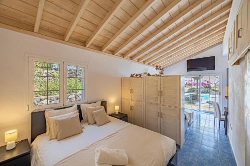a bedroom with a large bed in a room with windows at Casa Yuliana in Tijarafe