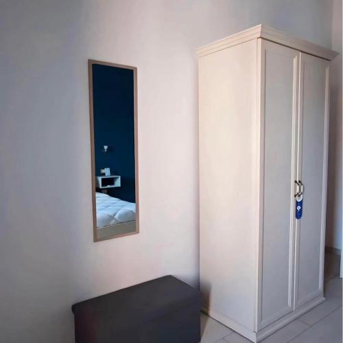 a room with a mirror and a bed and a cabinet at ELEGANCE GIBA Rooms in Giba