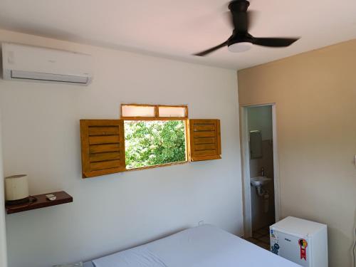 a bedroom with a bed and a window at Kitnet com veranda in Conde