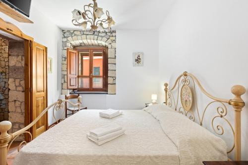 a bedroom with a bed with white sheets and a mirror at Meravigliosa Terrazza Vista Mare in Tresnuraghes