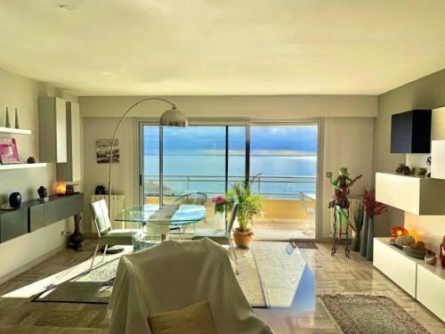 a living room with a table and a view of the ocean at MONACO - FANTASTIC Apartment and Sea View -1 bedroom 80m2 in Roquebrune-Cap-Martin