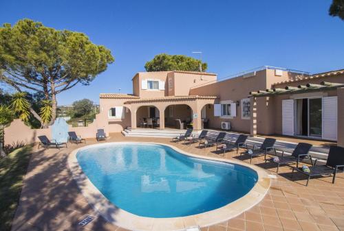 a villa with a swimming pool in front of a house at Villa Anita by Algarve Holidays in Quarteira