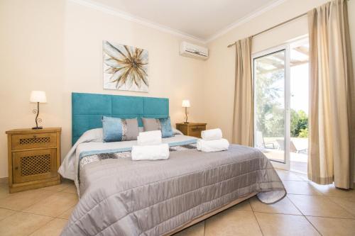 a bedroom with a large bed with a blue headboard at Villa Anita by Algarve Holidays in Quarteira