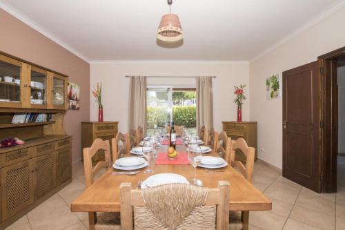 a dining room with a wooden table and chairs at Villa Anita by Algarve Holidays in Quarteira