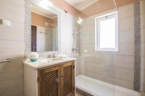 a bathroom with a sink and a shower and a tub at Villa Anita by Algarve Holidays in Quarteira