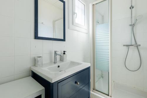 a white bathroom with a sink and a shower at L'Echo des Vagues -Conciergerieland in Vieux-Boucau-les-Bains