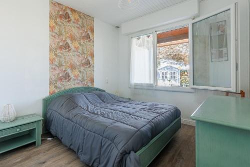 a bedroom with a bed in a room with a window at L'Echo des Vagues -Conciergerieland in Vieux-Boucau-les-Bains