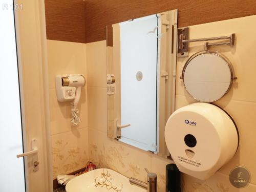 a bathroom with a toilet and a sink with a mirror at Vy An Hotel in Bảo Lộc
