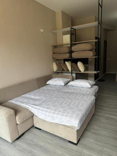 a bedroom with a bed and a shelf with towels at Forum View Apartments in Durrës