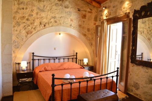 a bedroom with a bed in a room with a window at Roukouneli Traditional Stone House - Terrace & BBQ in Arménoi