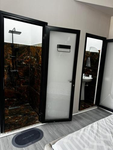 a room with two glass doors and a mirror at Forum View Apartments in Durrës