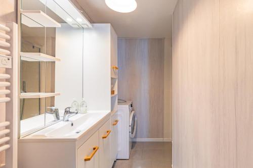 a bathroom with a sink and a washing machine at Maison de vacances La Menou in Saint-Pierre-dʼOléron