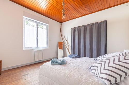 a bedroom with a large bed and a window at Maison de vacances La Menou in Saint-Pierre-dʼOléron