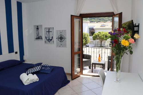 a bedroom with a bed and a vase of flowers on a table at BlueBay room Calabria in Vibo Valentia Marina
